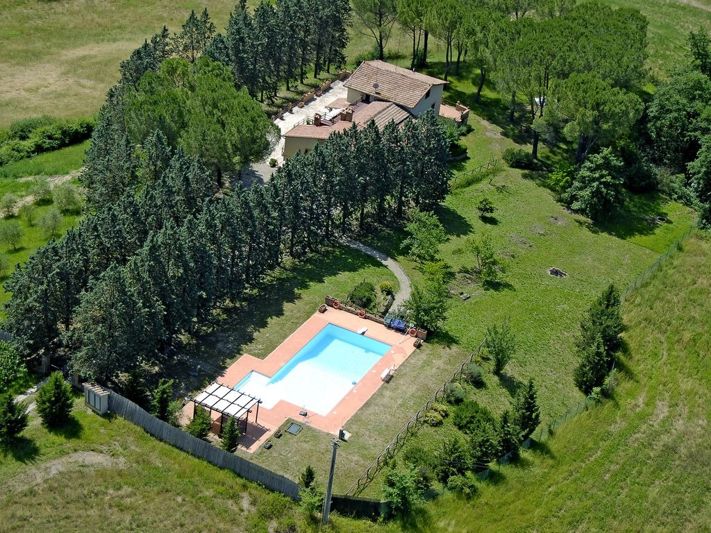 Vista aerea di Villa Talciona e piscina privata con pergolato, cipressi e colline del Chianti